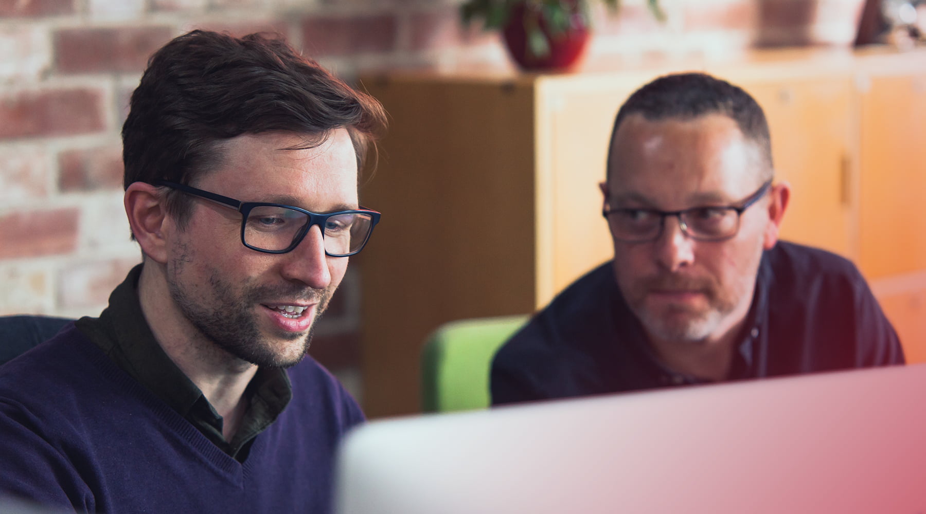 two people working together on computer